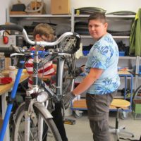Schüler reparieren ein Fahrrad in der Fahrradwerkstatt Schüler reparieren ein Fahrrad in der Fahrradwerkstatt