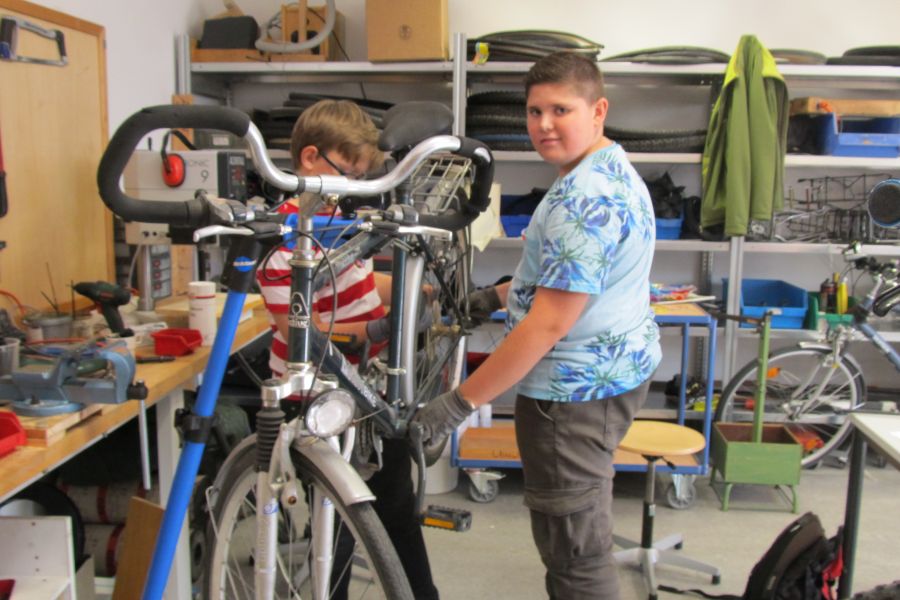 Schüler reparieren ein Fahrrad in der Fahrradwerkstatt Schüler reparieren ein Fahrrad in der Fahrradwerkstatt