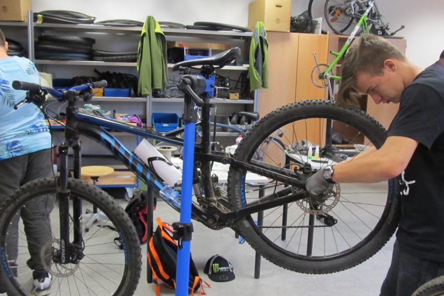 Schüler reparieren ein Fahrrad in der Fahrradwerkstatt Schüler reparieren ein Fahrrad in der Fahrradwerkstatt